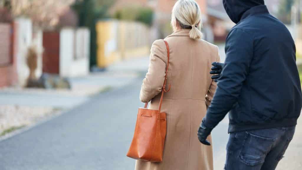 Man with hoodie about to commit a robbery on female victim on public street